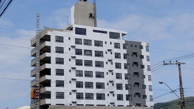 Edifício em execução, com fachada clara e áreas ainda em acabamento.