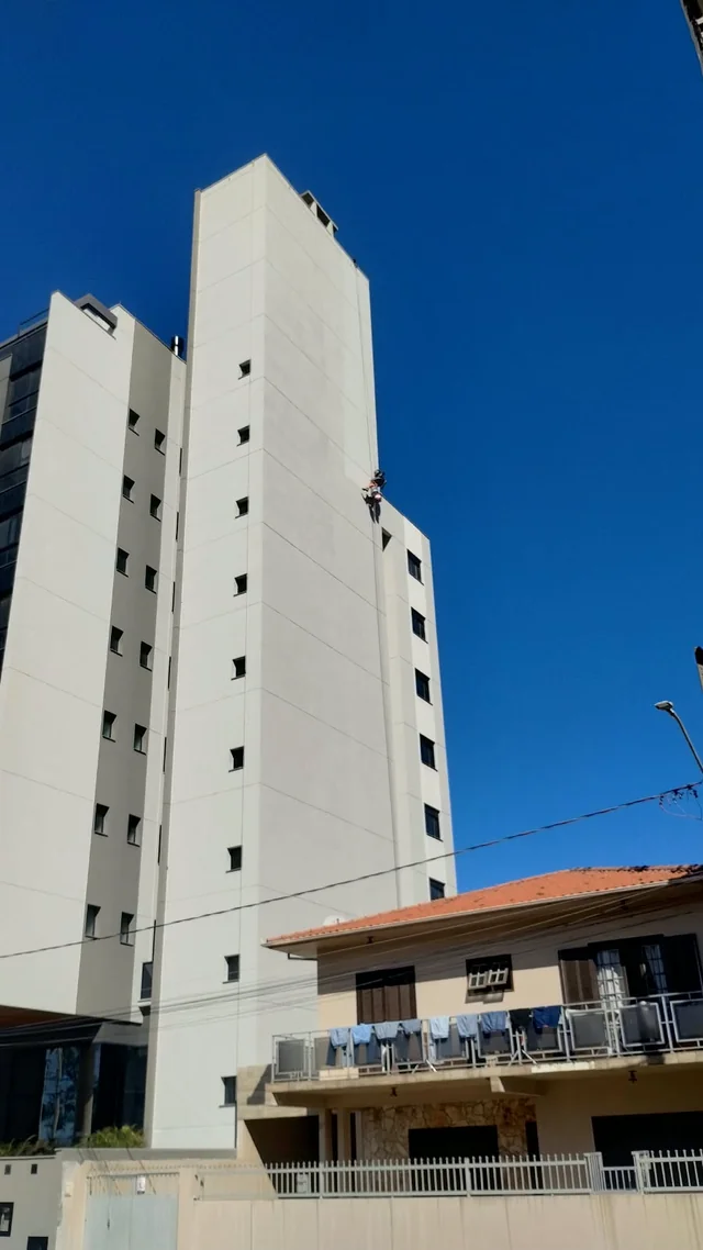 Edifício de fachada clara fotografado de baixo para cima.