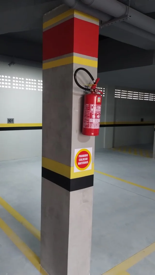 Pilar de garagem com faixas amarelas, pretas e vermelhas.