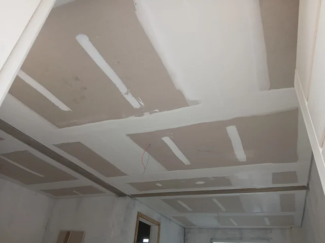 Forro de placas de drywall com juntas tratadas, antes da pintura.