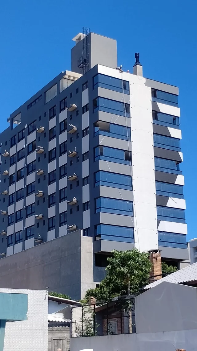 Edifício com fachada azul e cinza, visto da rua.