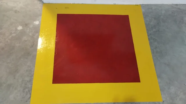 Pintura de piso em vermelho e amarelo, com acabamento em execução.