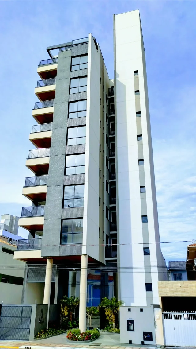 Vista em perspectiva de edifício com varandas e fachada clara.
